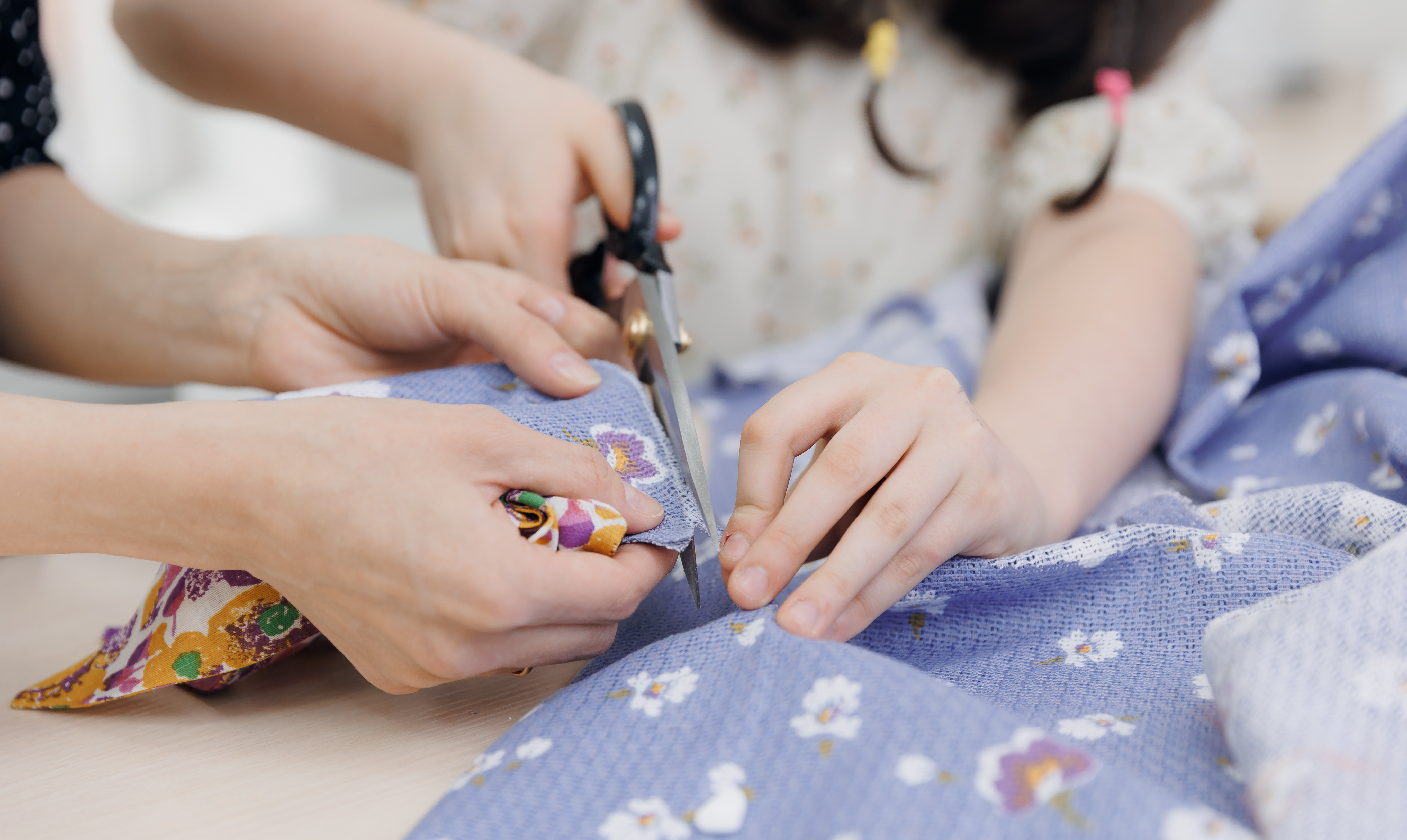 kid using scissors to cut fabric